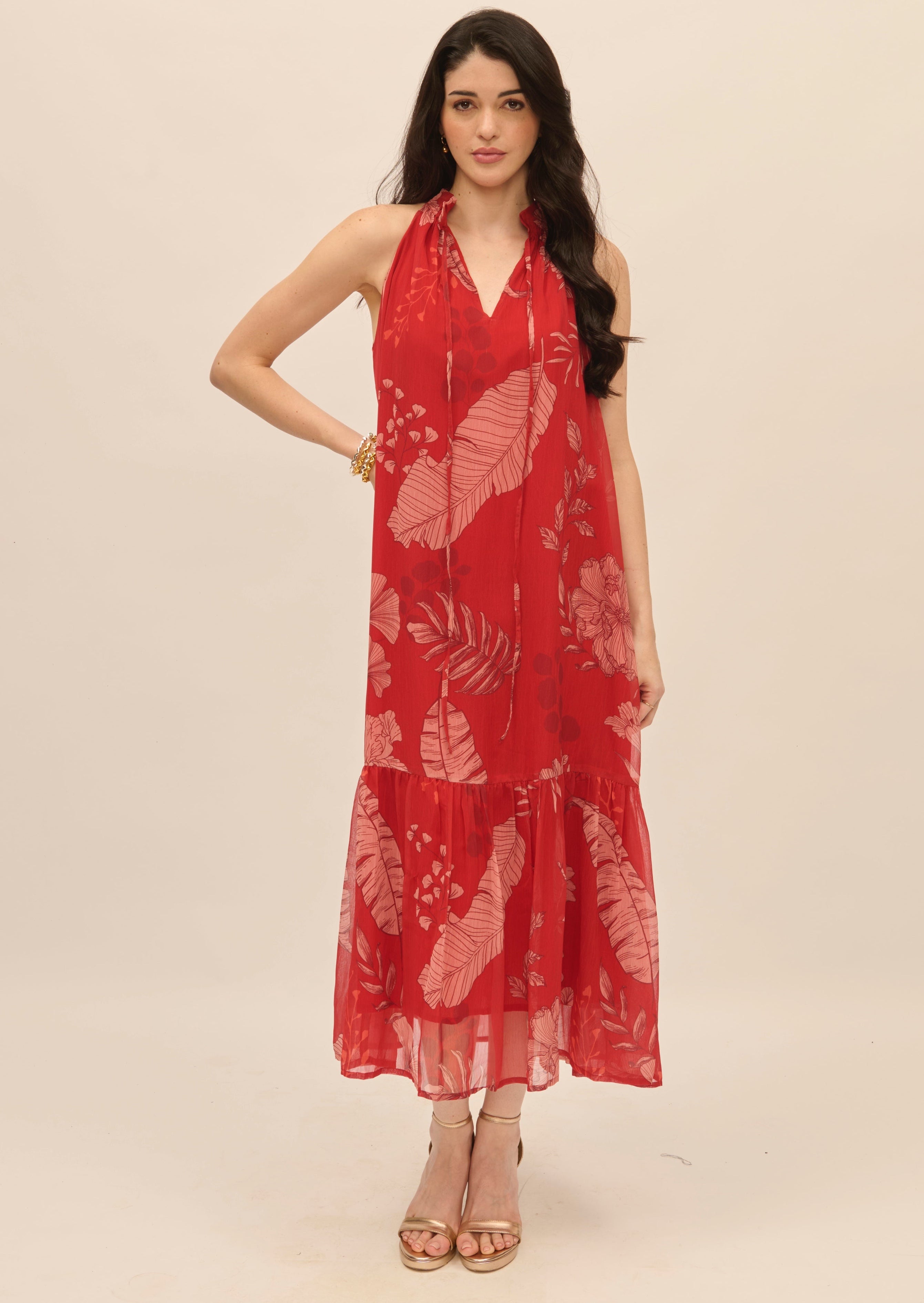 Woman wearing a red floral dress on a beige background